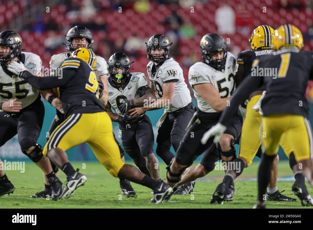 Tampa Bay, FL USA;  Wake Forest Demon Deacons quarterback Sam Hartman (10) hands off the ball to running back Justice Ellison (6) during the Union Hom Stock Photo