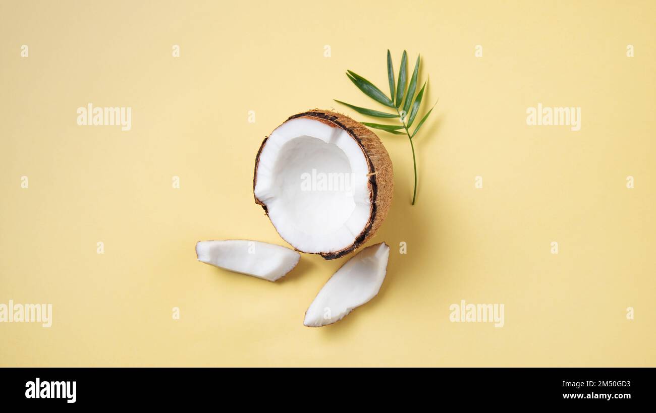 Eco friendly flat lay. Fresh coconut and slices  on yellow  background. Healthy and vegan food. Top view and copy space image Stock Photo