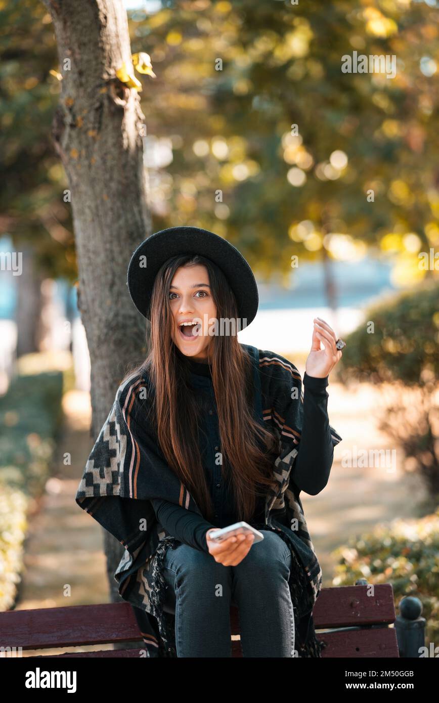 Young woman on a bench in the autumn park Stock Photo - Alamy