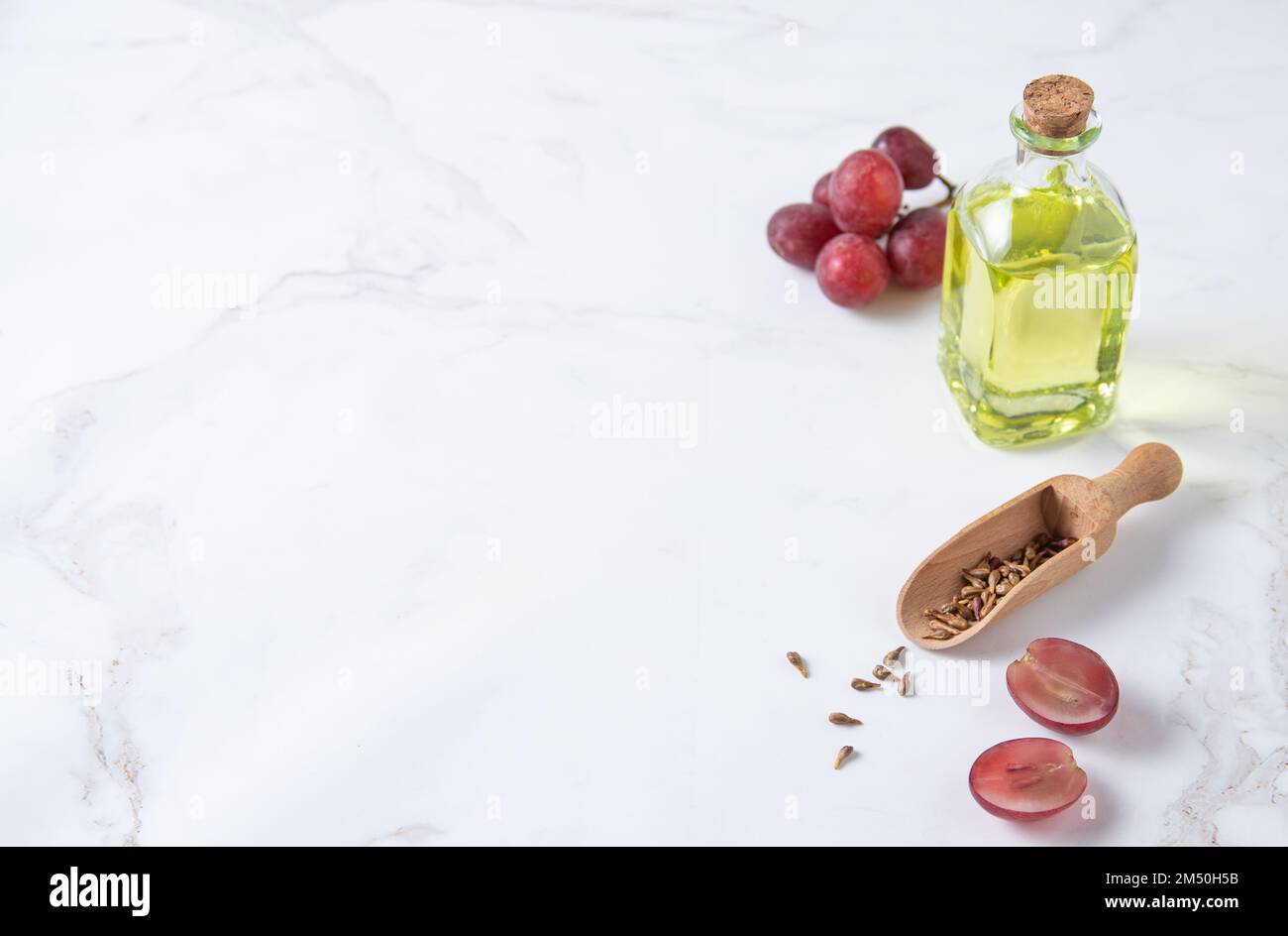 natural dietary and vegan grape seed oil in glass bottles on a white marble background. Healthy food and lifestyle. Top view and copy space Stock Photo