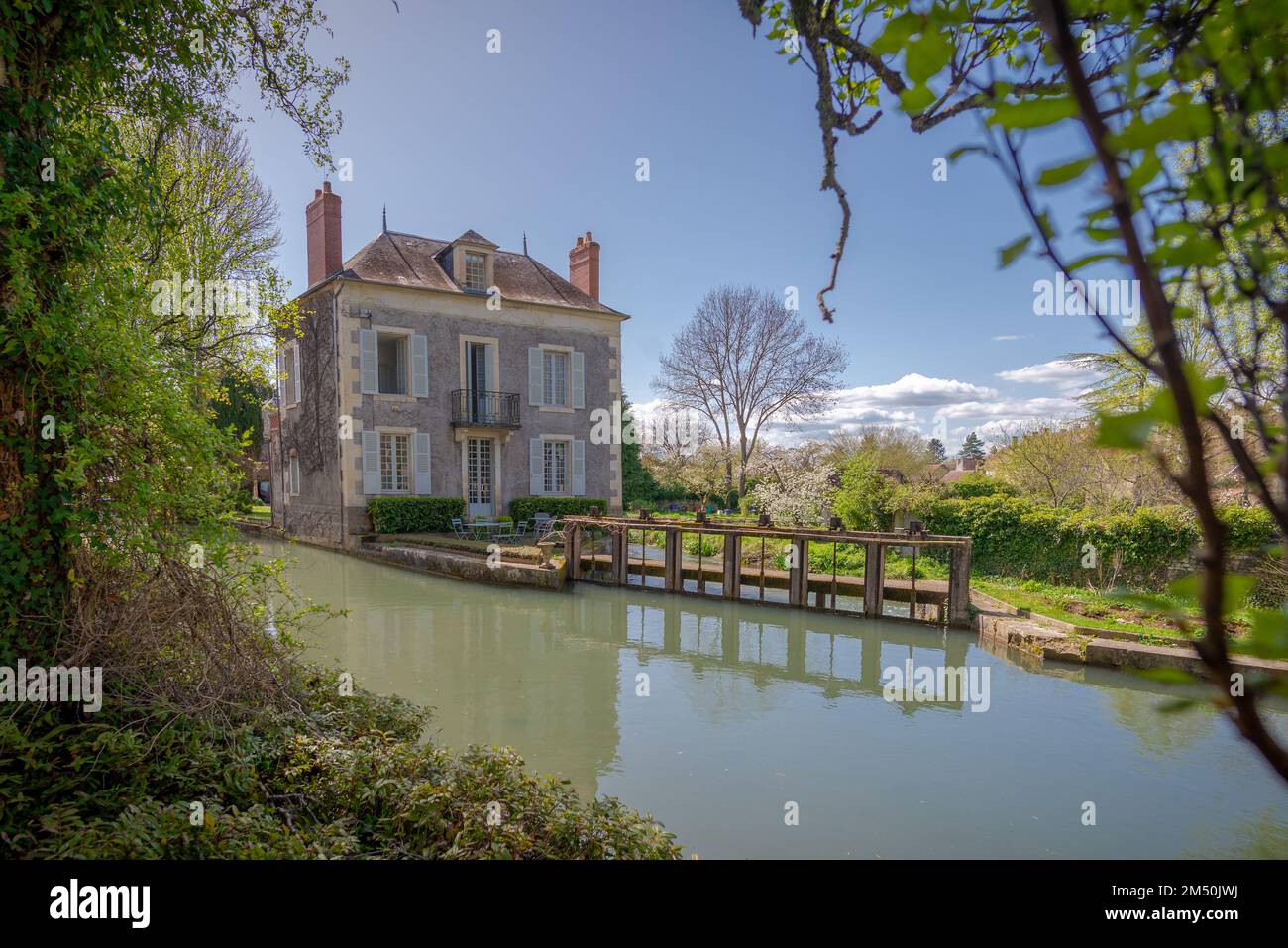 The lock keeper's house set along a canal and taken on a sunny spring day in Donzy, Burgundy, France Stock Photo