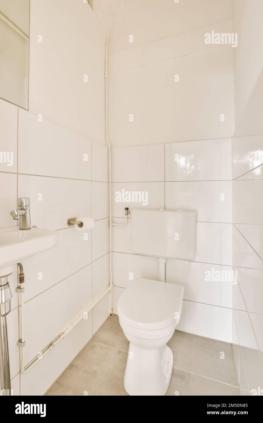 a bathroom with white tiles on the walls, and a toilet in the corner