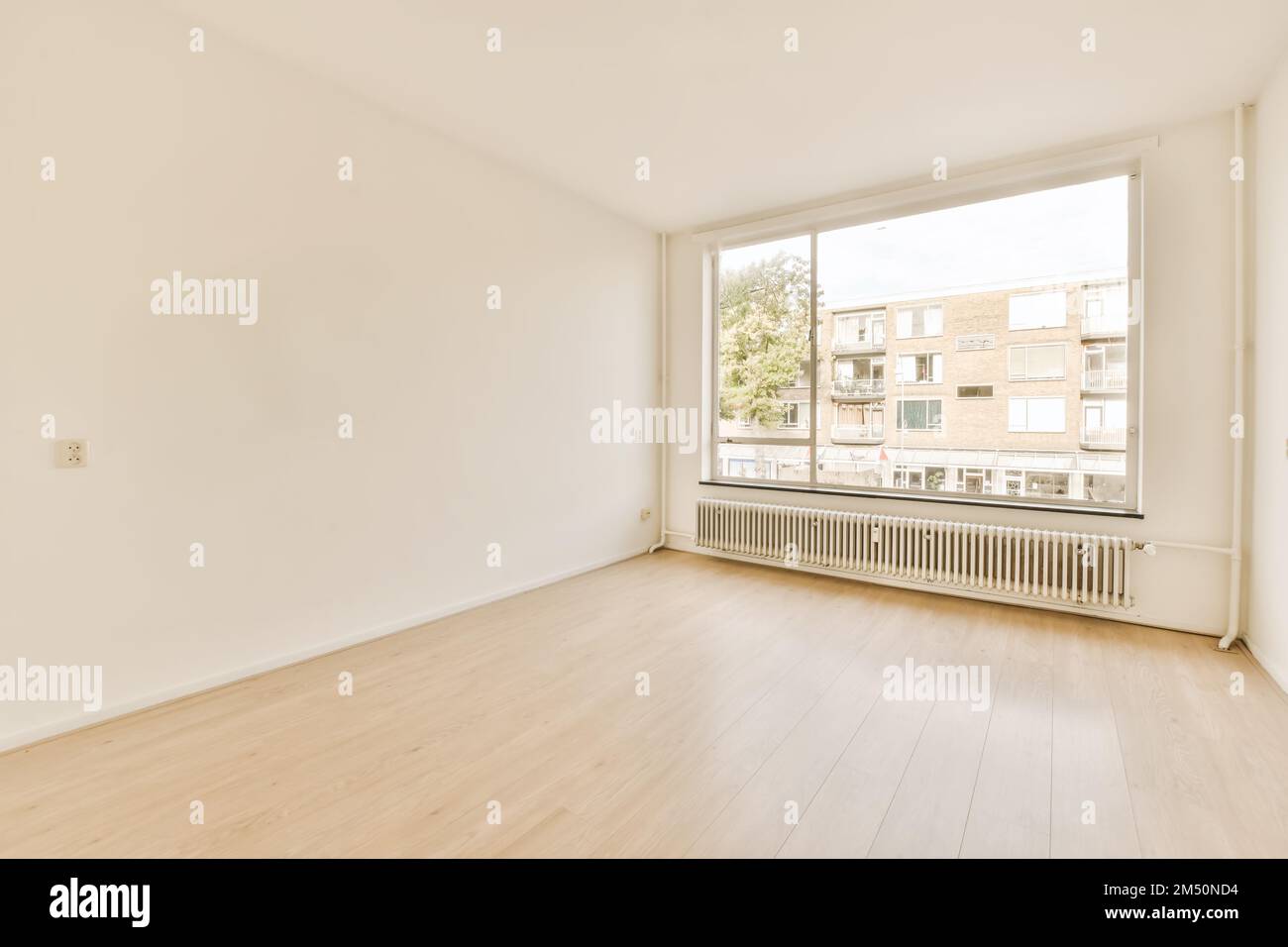 an empty room with white walls and hardwood flooring, there is a large