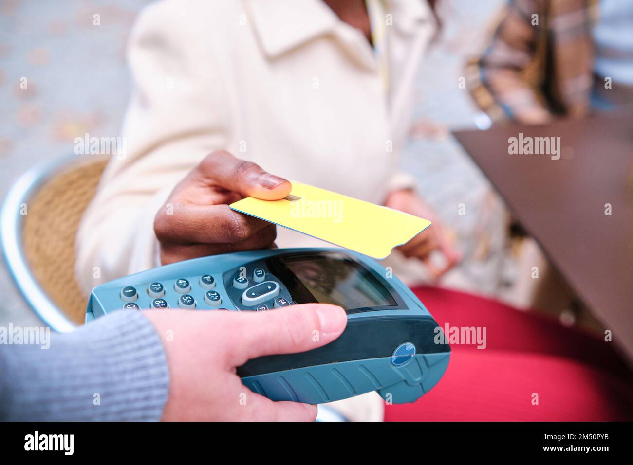 Close-up view of a person making contactless payment with credit card. Stock Photo