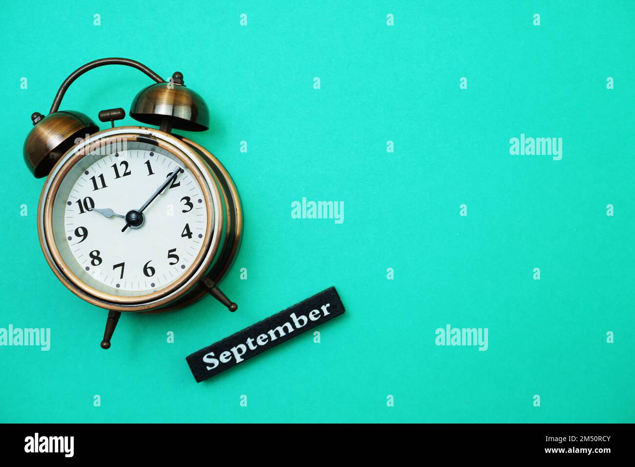 Alarm clock and September calendar with space copy on green mint ...