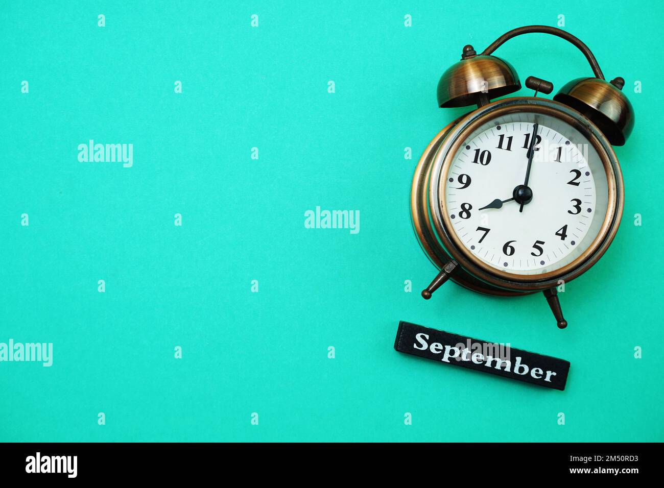Alarm clock and September calendar with space copy on green mint ...