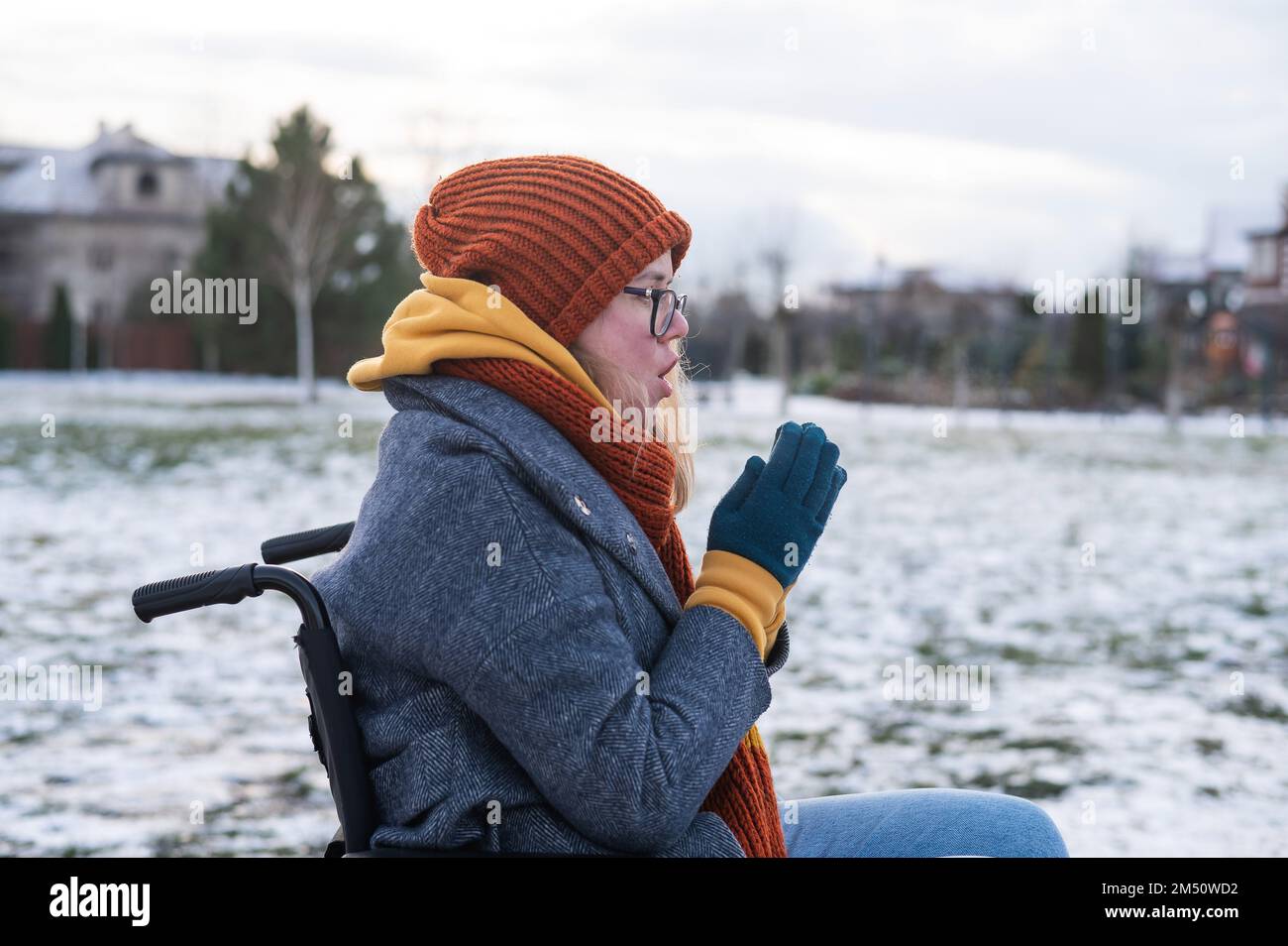 Caucasian woman freezes in a wheelchair in winter. Stock Photo