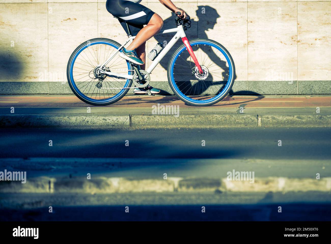Person riding a bicycle casting shadow on the wall Stock Photo Alamy