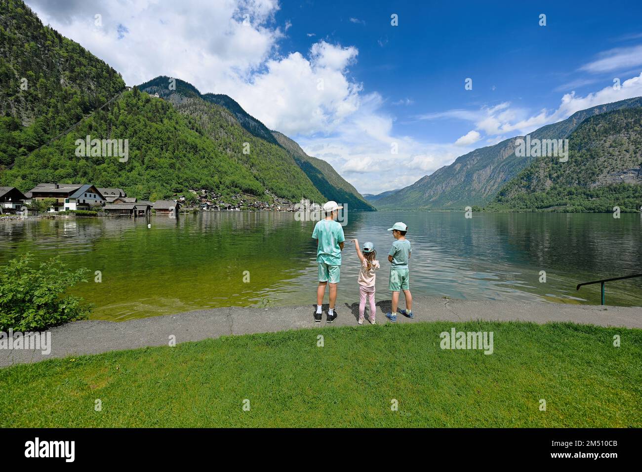 Three kids over Austrian alps lake in Hallstatt, Salzkammergut, Austria. Stock Photo