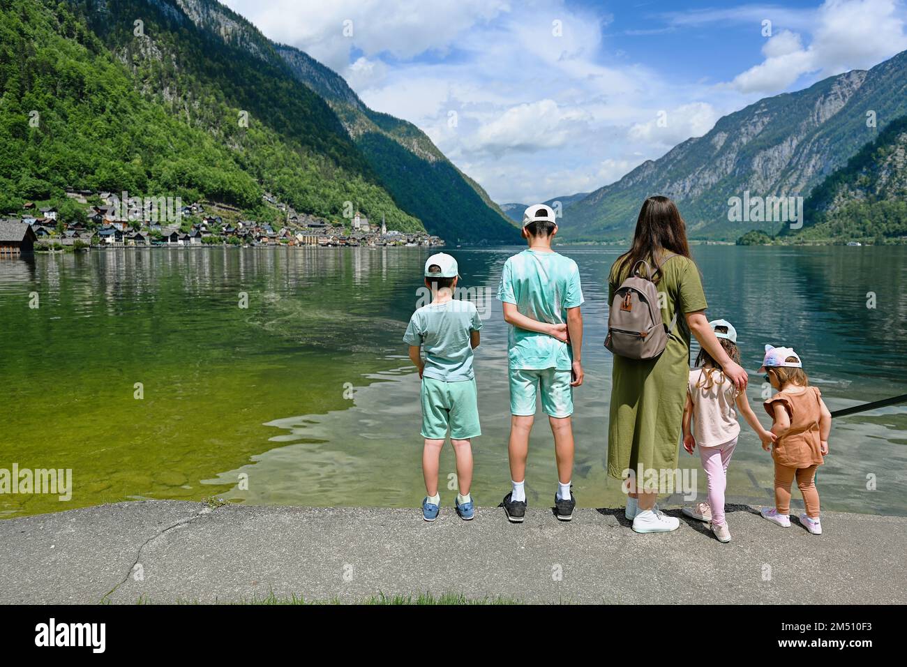 Back of mother with four children over Austrian alps lake in Hallstatt, Salzkammergut, Austria. Stock Photo