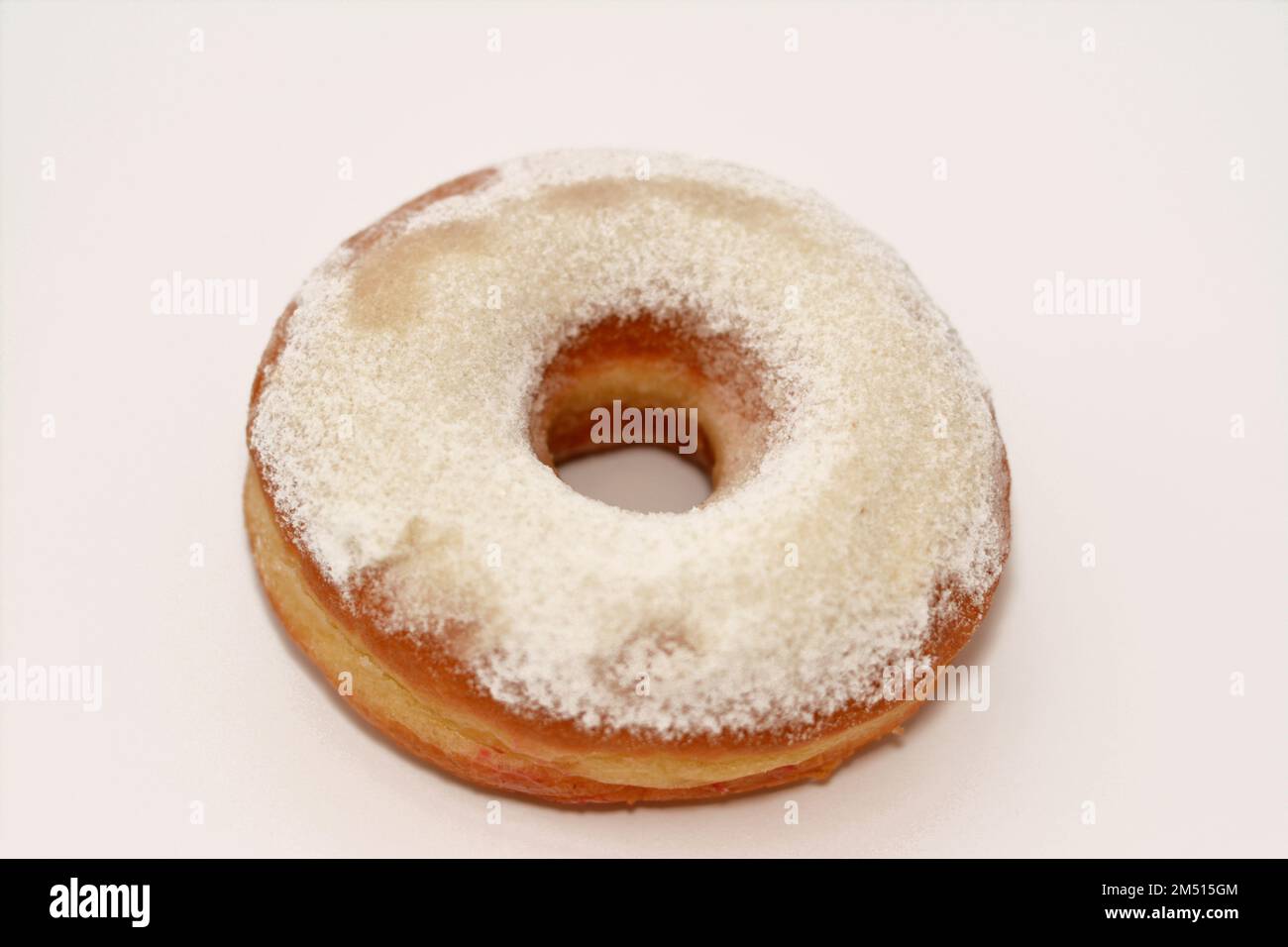 Powdered icing sugar ring donut, A glazed, yeast raised, American style ring doughnut with topping of confectioners' finely ground sugar, type of food Stock Photo