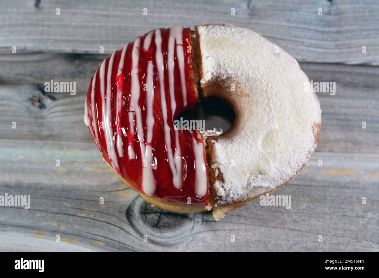 Icing powdered confectioners' sugar and Strawberry flavored ring donut, A glazed, yeast raised, American style ring doughnut with topping, type of foo Stock Photo