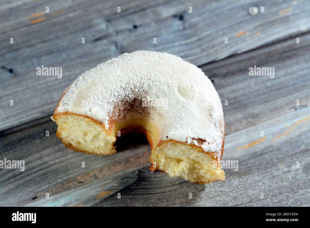 Powdered icing sugar ring donut, A glazed, yeast raised, American style ring doughnut with topping of confectioners' finely ground sugar, type of food Stock Photo