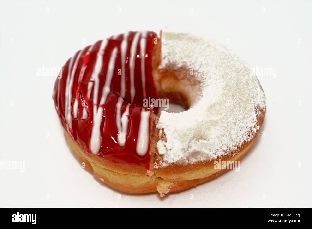Icing powdered confectioners' sugar and Strawberry flavored ring donut, A glazed, yeast raised, American style ring doughnut with topping, type of foo Stock Photo