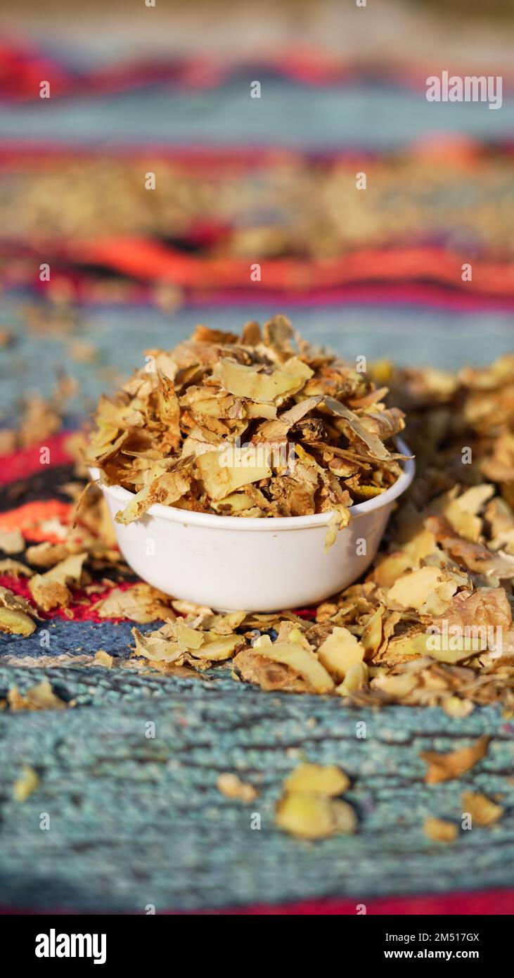 A pile of Ginger roots peeled with knife over chopping block. Ginger or ...