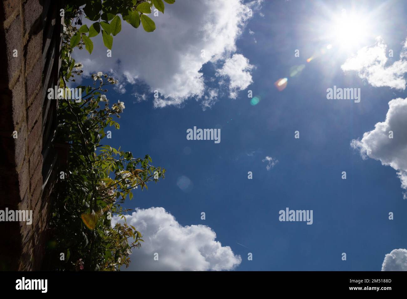 Blue sky with white clouds and lens flare sun Stock Photo - Alamy
