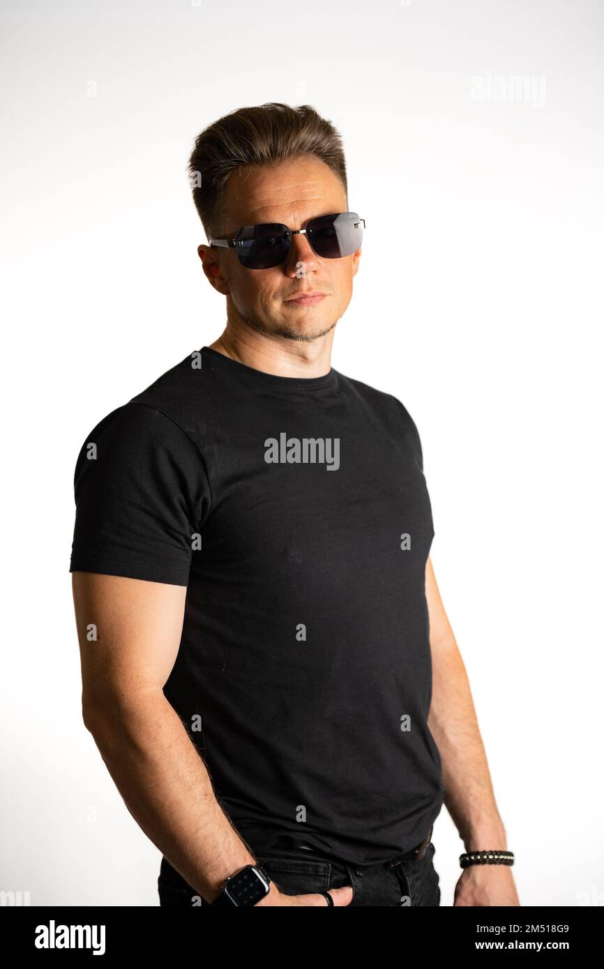 Portrait of cool young guy in black tshirt and sunglasses isolated against a white background Stock Photo