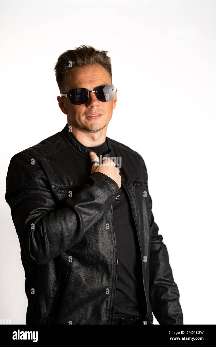 Portrait of handsome male. Sexy stylish man dressed in a leather jacket and sunglasses. Fashion hipster male isolated on white background in studio Stock Photo