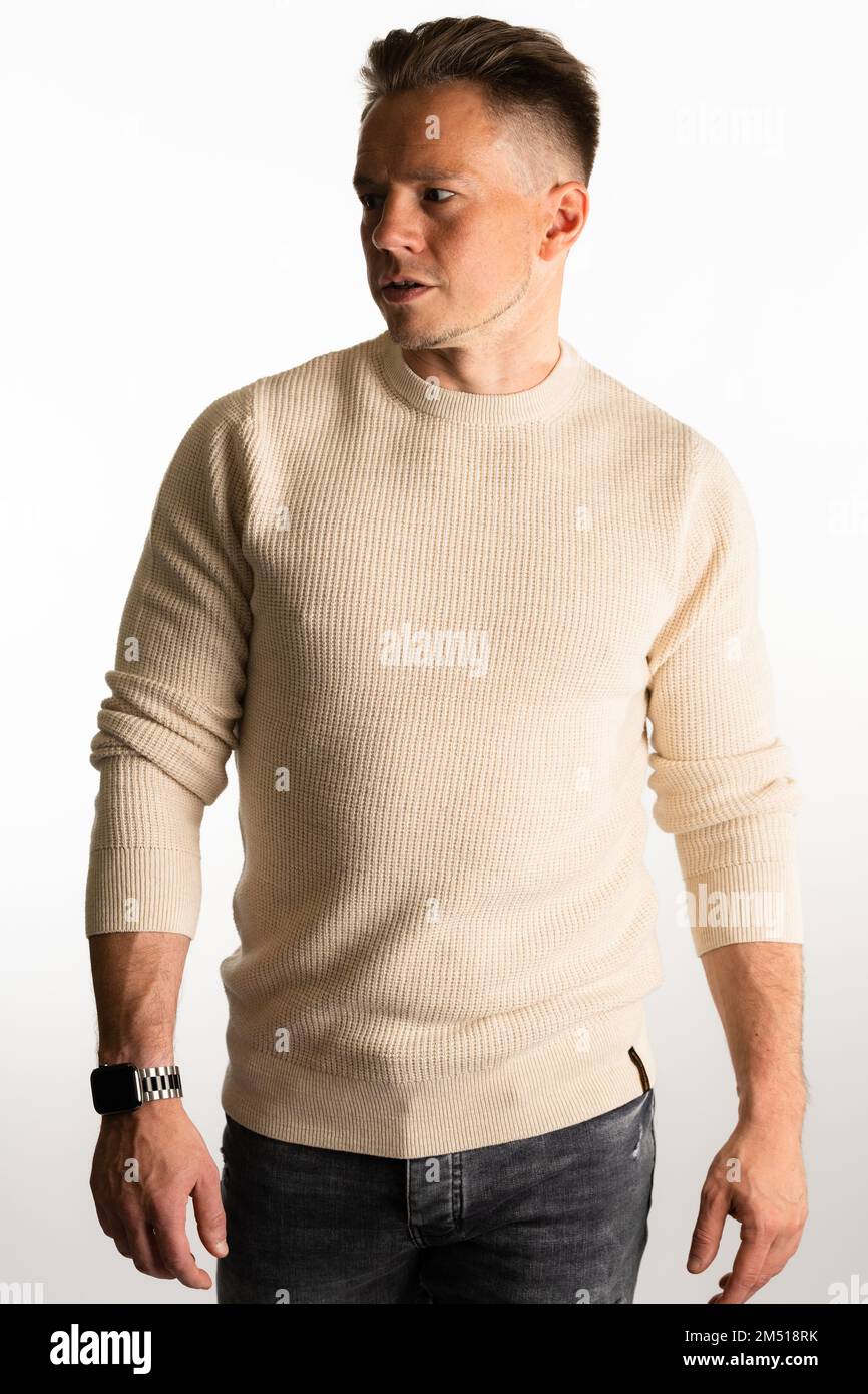 Photo of young handsome attractive serious wearing a cream sweater isolated on white background Stock Photo