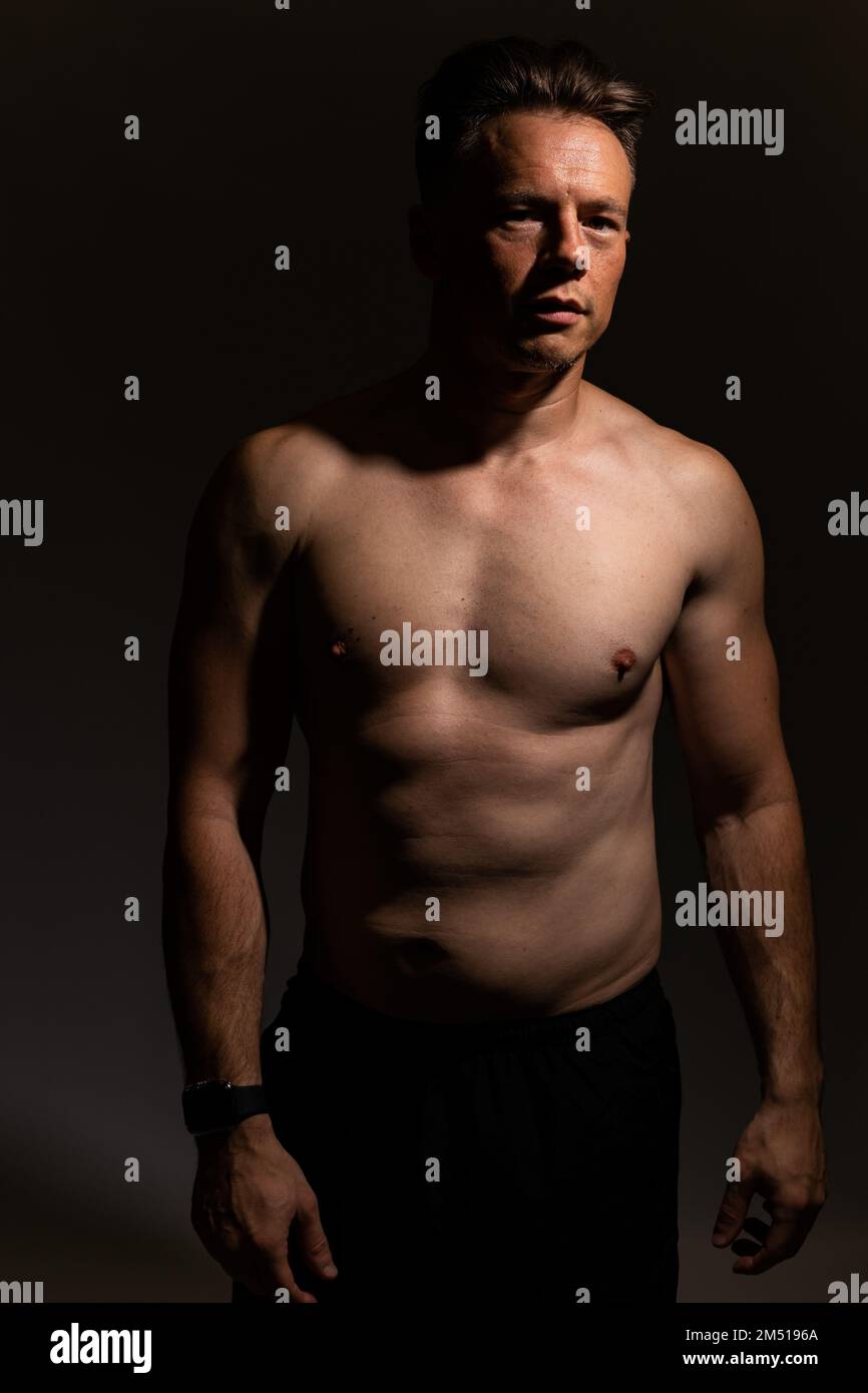 Sexy portrait of muscular handsome topless male isolated against a grey background Stock Photo
