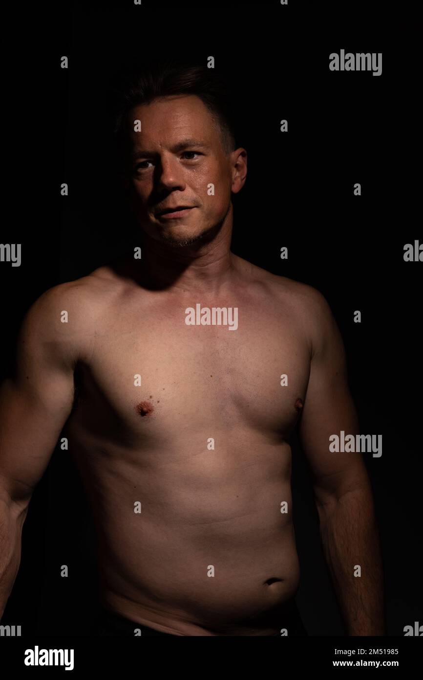 Sexy portrait of muscular handsome topless male isolated against a black background Stock Photo