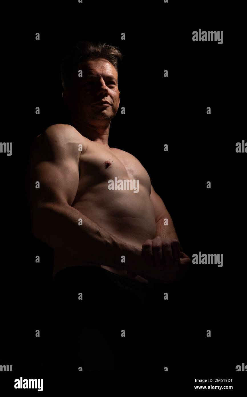 Sexy portrait of muscular handsome topless male isolated against a black background Stock Photo