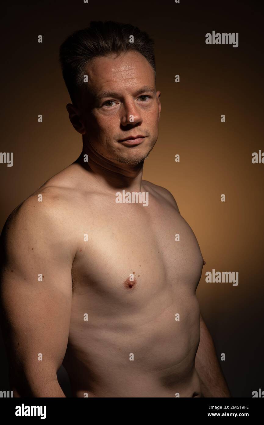 Sexy portrait of muscular handsome topless male isolated against a coloured background Stock Photo