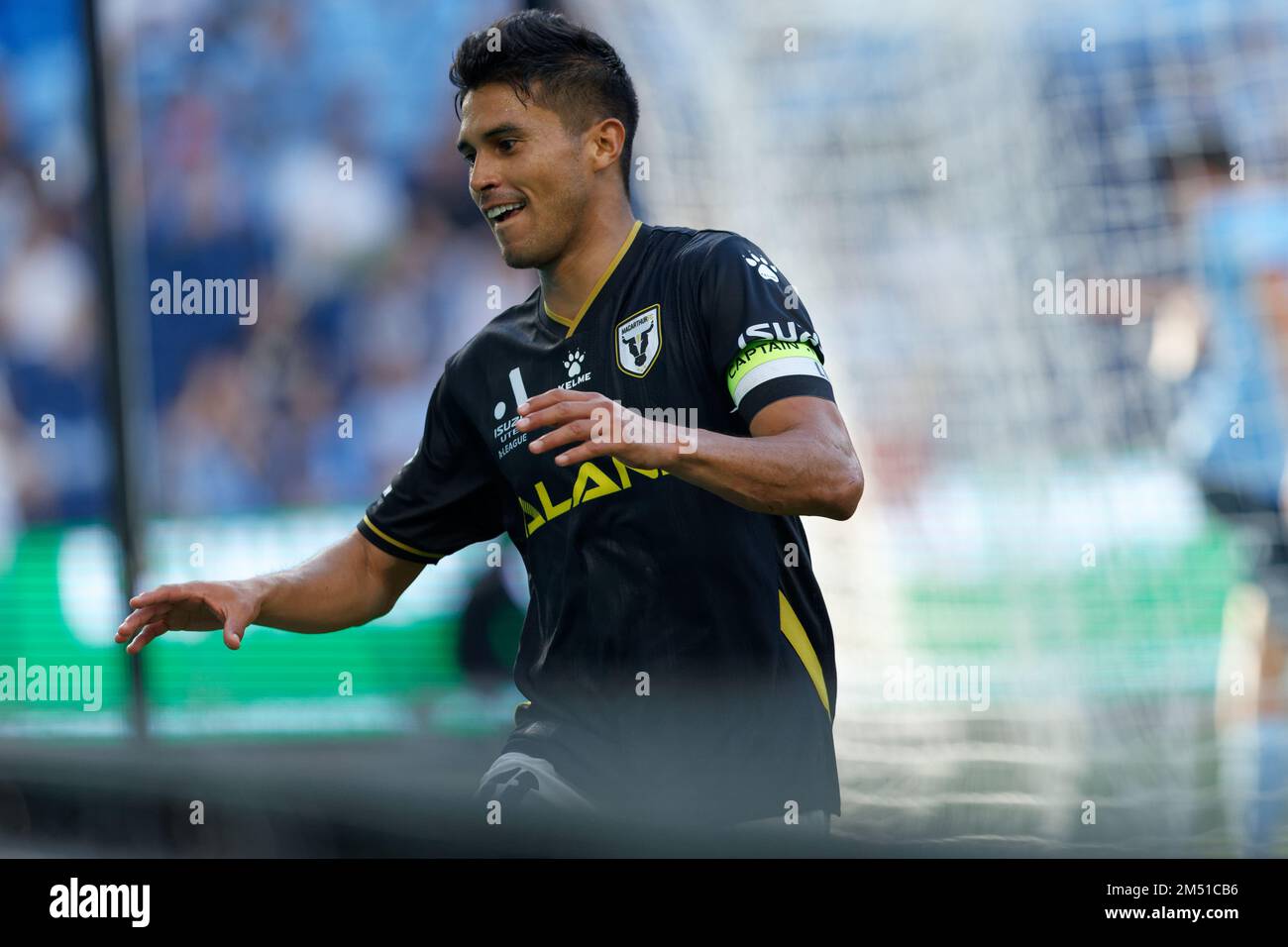 Ulises Davila of Macarthur FC jumps the digital signage barrier to  celebrate with supporters during the match between Sydney FC and Macarthur  at Allianz Stadium on December 24, 2022 in Sydney, Australia