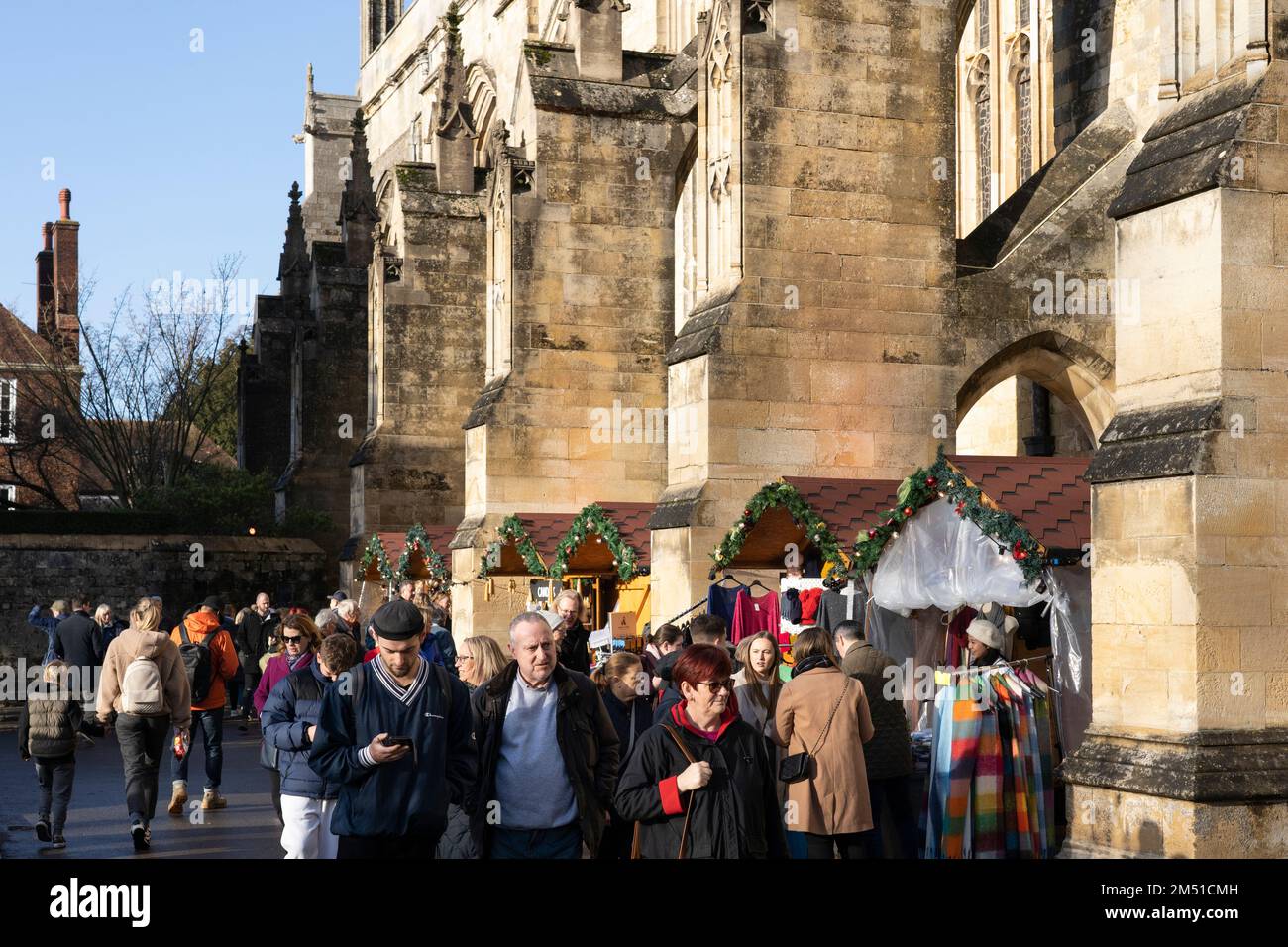 Christmas shoppers at Winchester Christmas market with stalls inbetween
