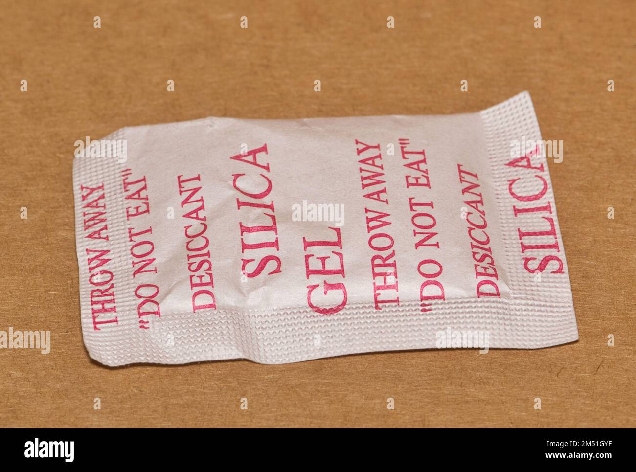 Single Silica gel packet isolated in a cardboard box, flat lay. Porous