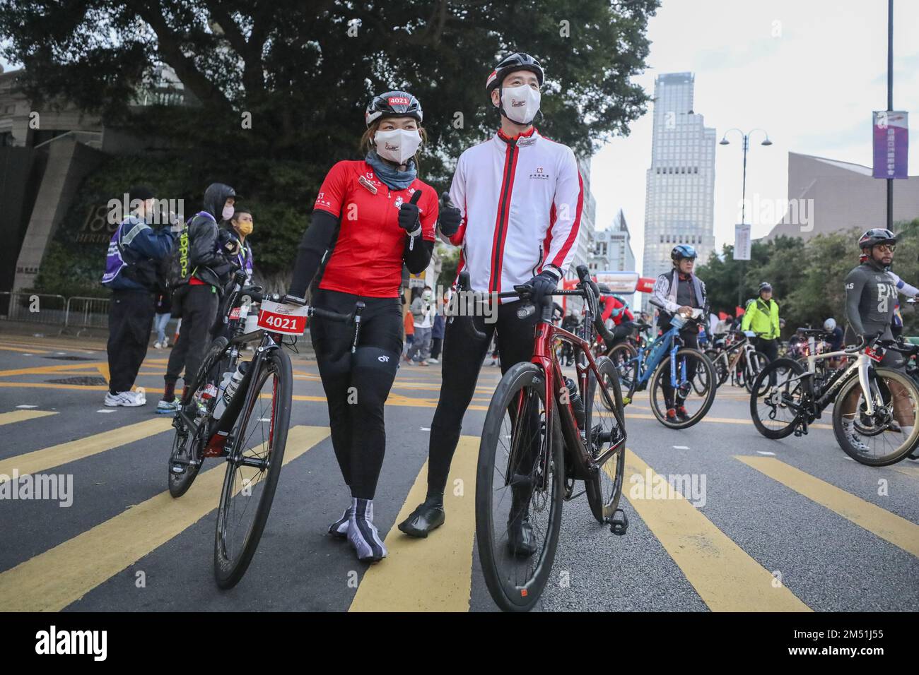 Sarah Lee Wai-sze (left) and SHK executive director Adam Kwok Kai-fai  pose for a photo after arriving in Tsim Sha Tsui. Hong Kong Cyclothon 2022 is held despite the cold weather. 18DEC22 SCMP/Xiaomei Chen Stock Photo
