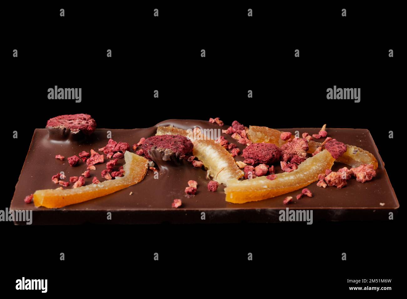 Peeled Raspberry Chocolate bar with candied orange peel and raspberry isolated on black ...
