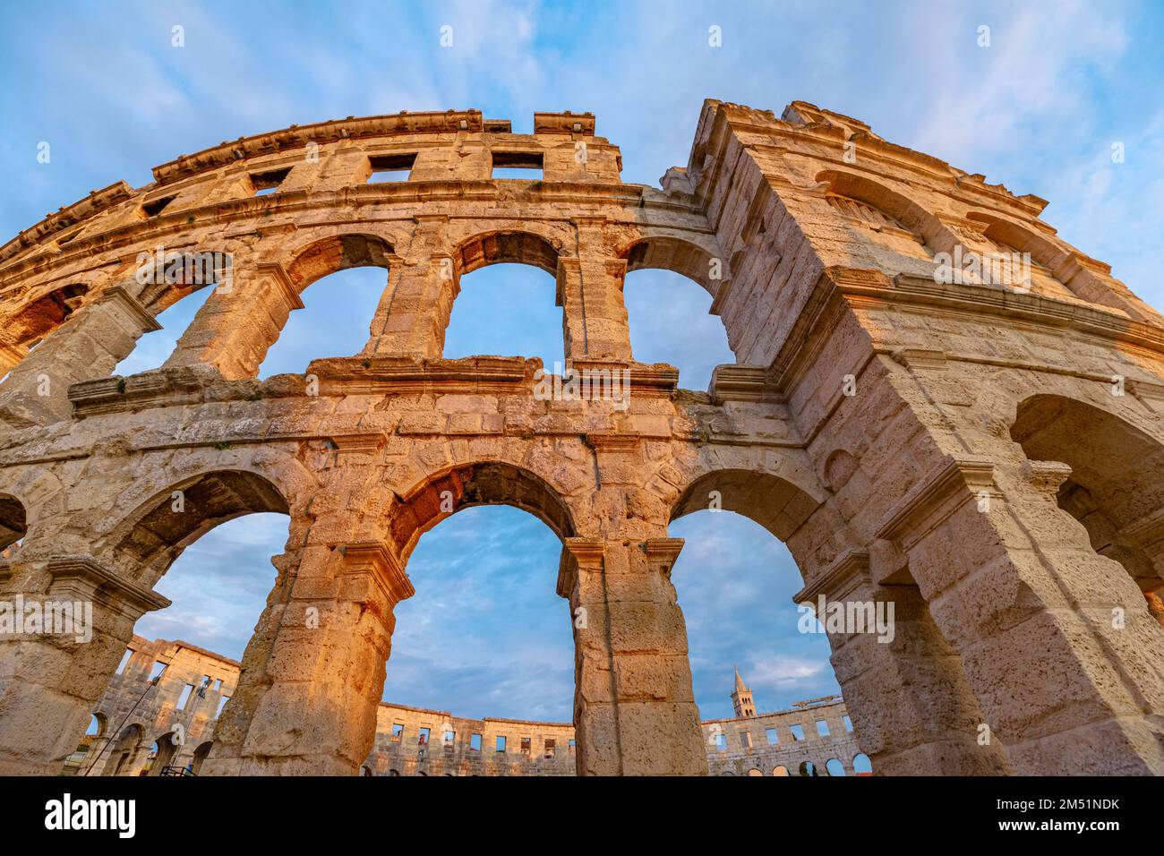 Pula Amphitheater at sunset, also known as Coliseum of Pula, is a well-preserved Roman amphitheater in Pula, Istria, Croatia. ancient arena was built Stock Photo
