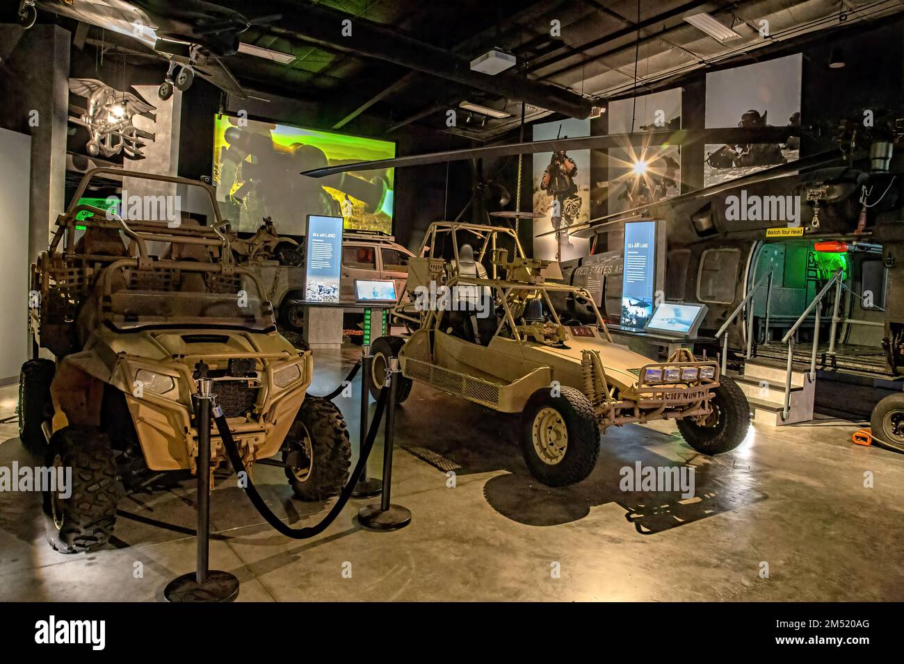 All terrain vehicles at the Navy SEAL museum in Fort Pierce with video playing in the background and a helicopter off to the side. Stock Photo