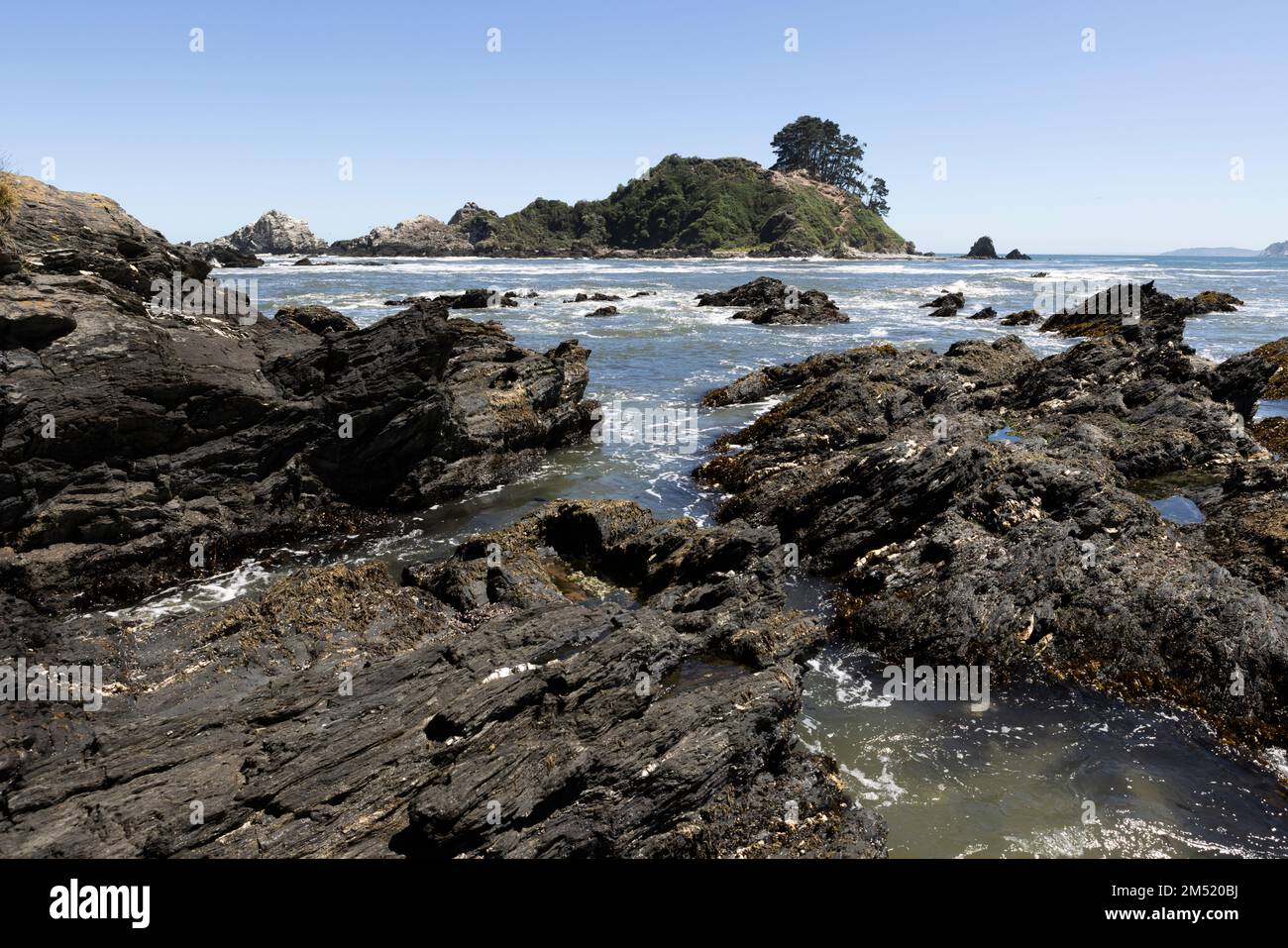 Isla Maiquillahue and big, serrated rocks in the Pacific Ocean of Chile ...