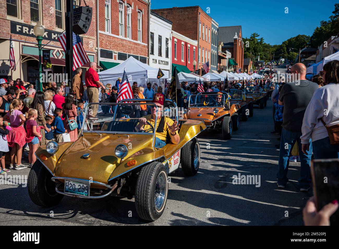 The Shriners in gold dune buggy in small town during Applefest parade