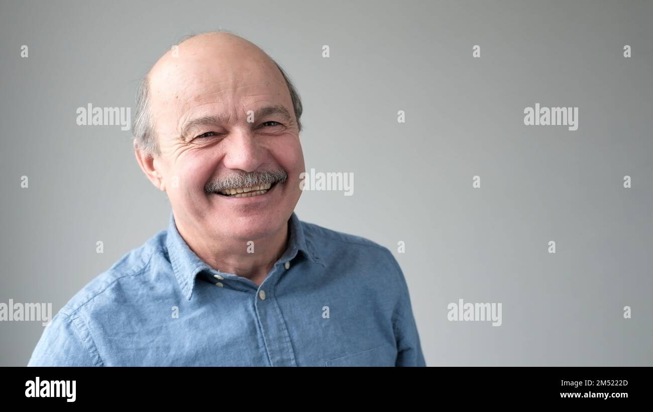 Cheerful senior man who is looking at camera and smiling. Stock Photo