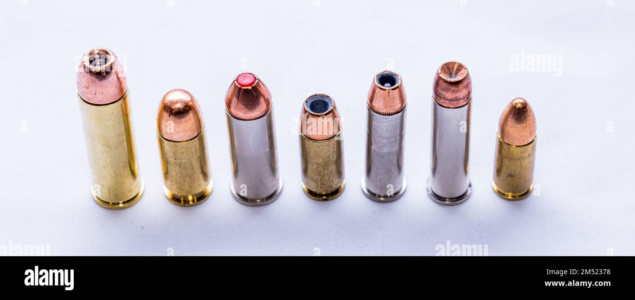 Seven bullets, 9mm, 38 special, 357 magnum, 40 caliber, 44 spl and a 454 casull together on a white background Stock Photo