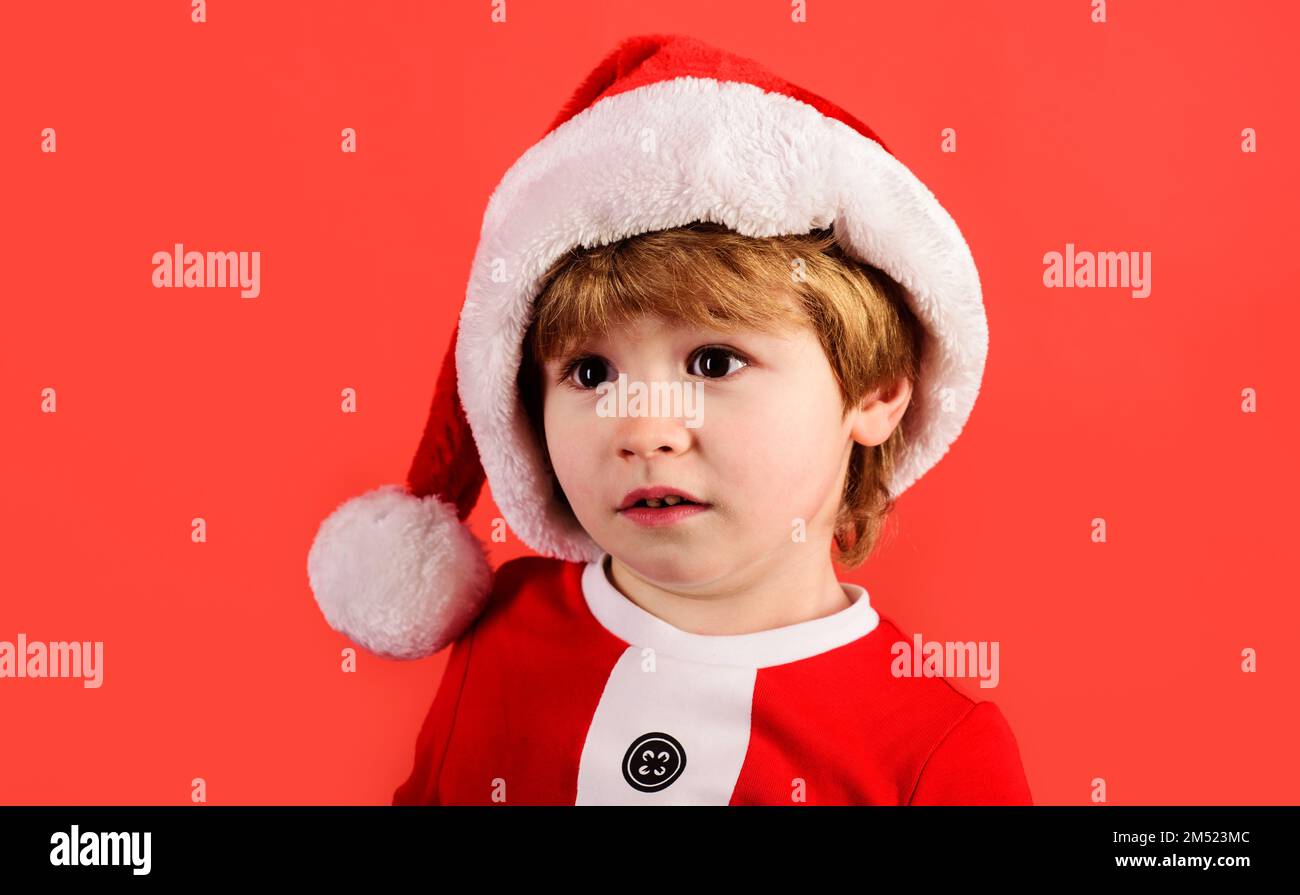 Merry christmas. Little Santas helper. Happy New Year holidays. Surprised child in Santa hat. Stock Photo