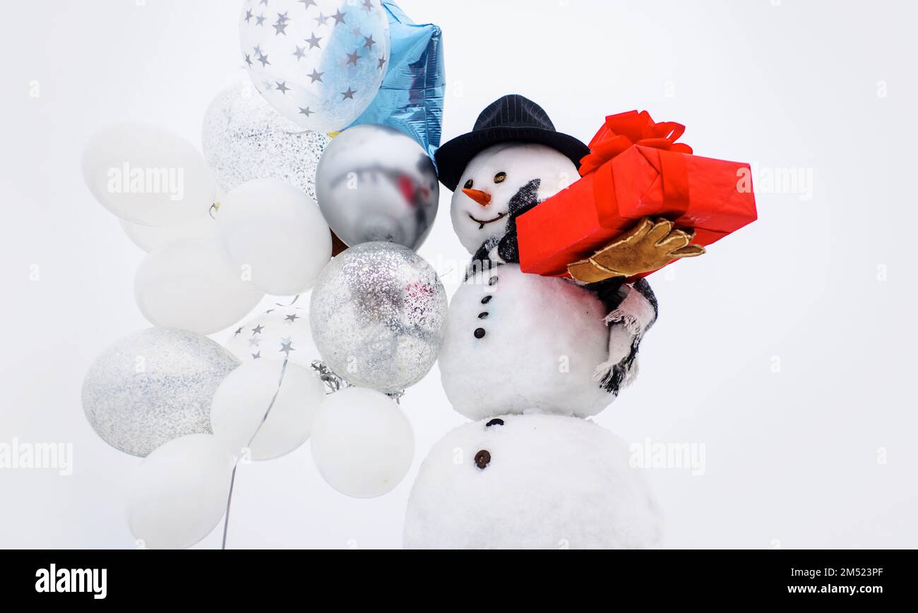 Greeting snowman gentleman with air balloons and gift. Merry Christmas and Happy New year. Stock Photo