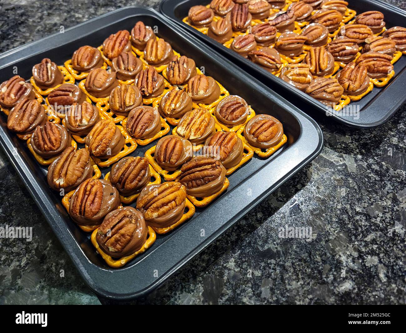 Melted chocolate and caramel candies with pecans on pretzels bites on