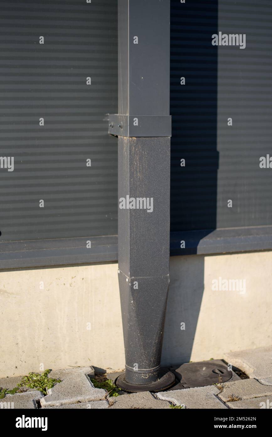 Close up of down spout drain going into the ground. rain drain pipe