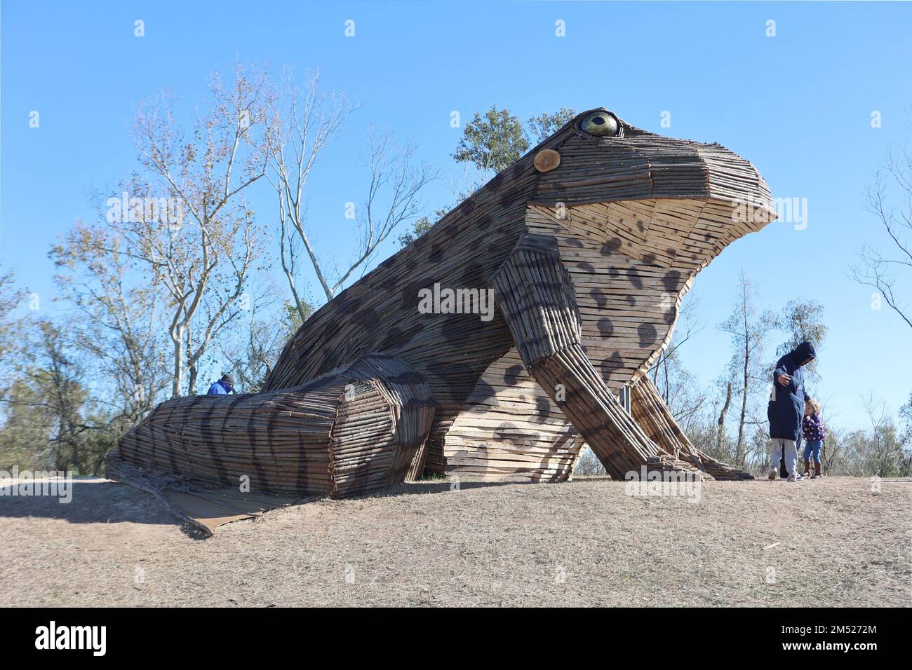 A family take some photos in front of giant Bullfrog Bonfire the is