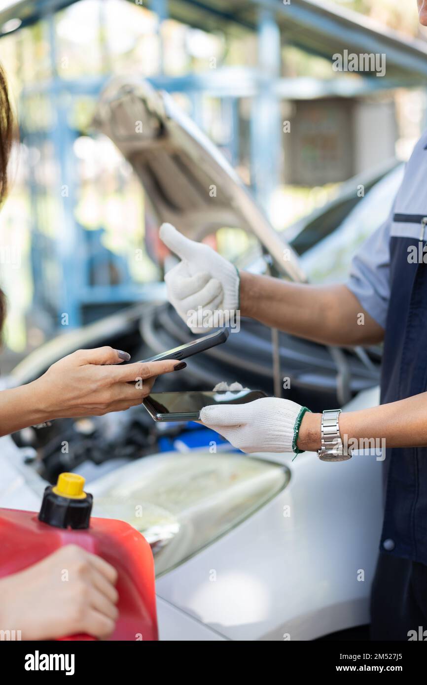 Asian women get contact numbers from auto mechanics after fixing the car engine problem and QR