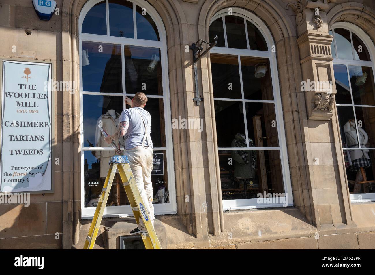 Male painter working painting sash window frames at the Woollen mill