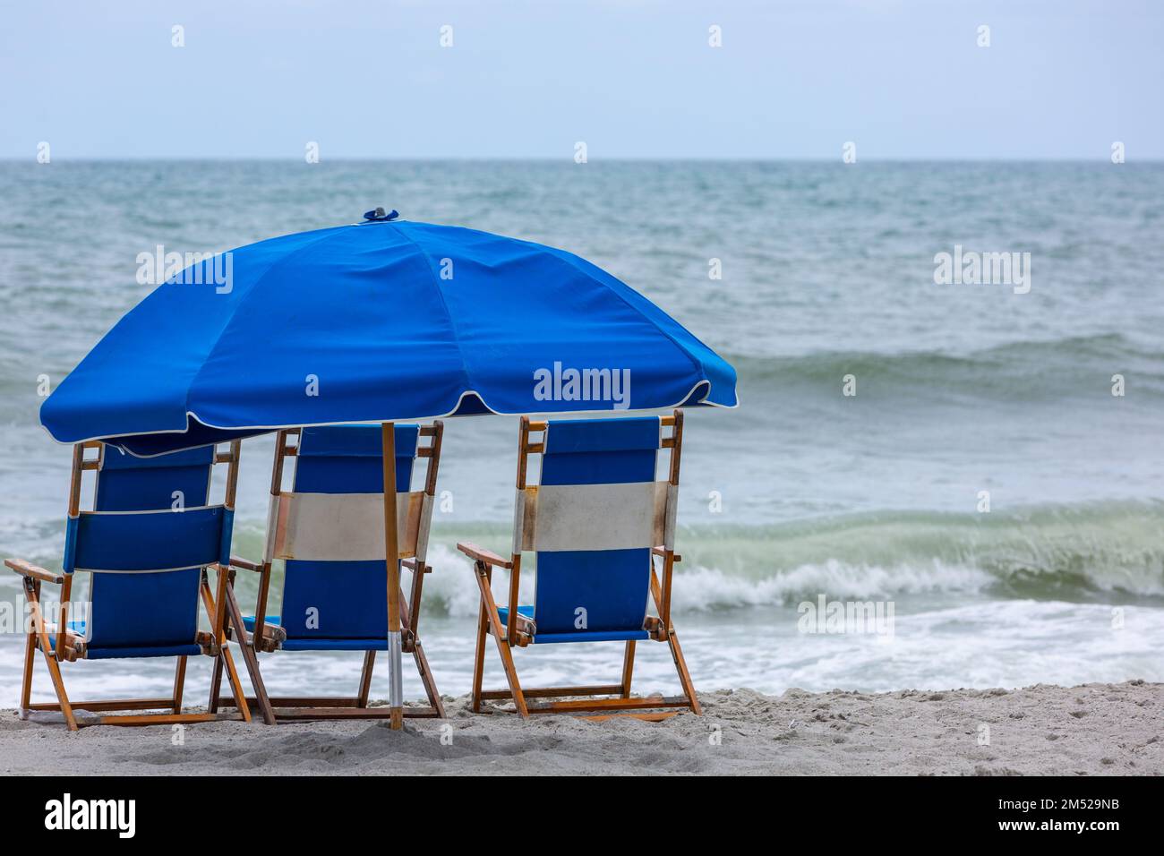 Blue beach chairs and an umbrella at Myrtle Beach, South Carolina, USA