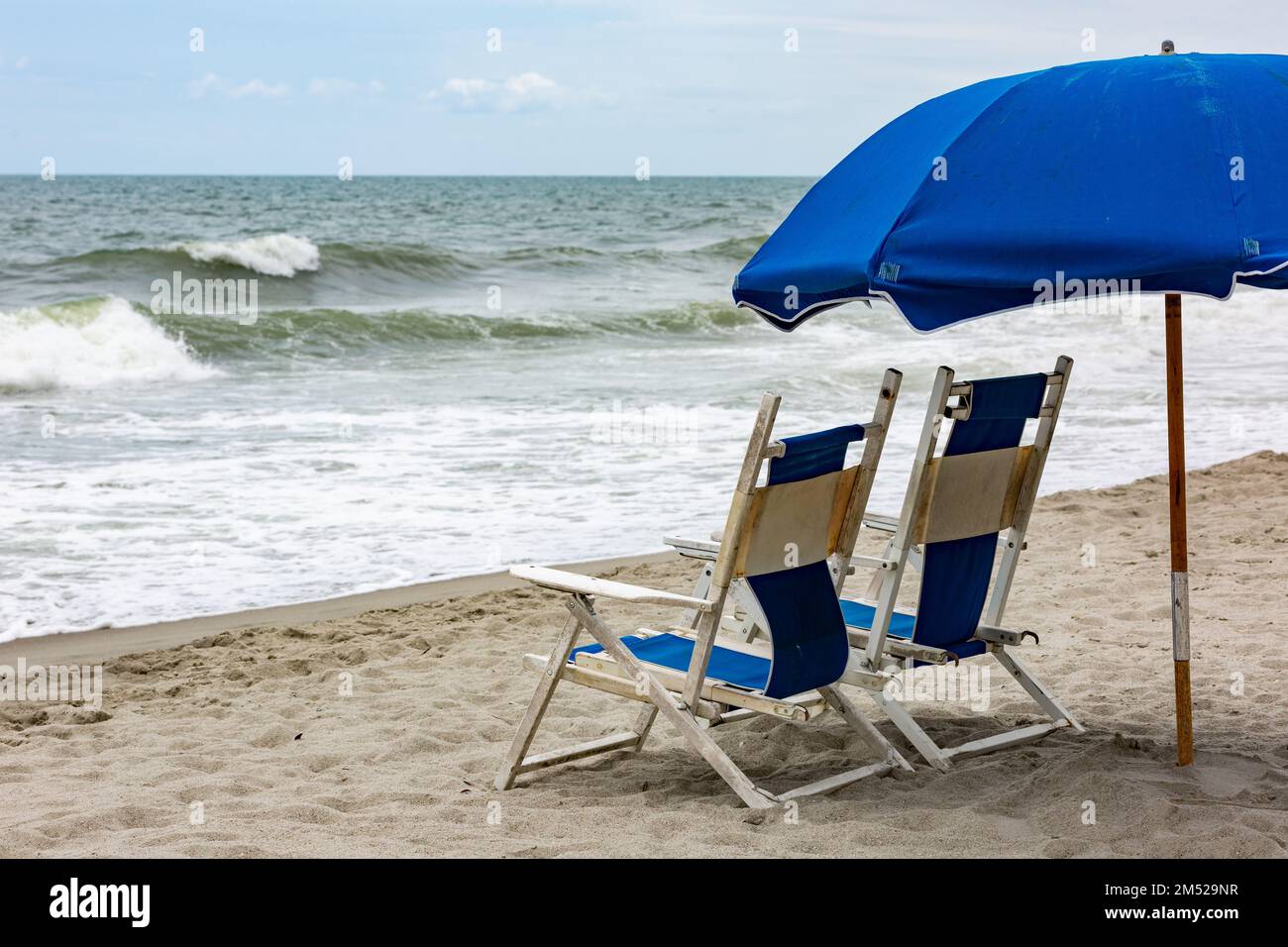 Blue beach chairs and an umbrella at Myrtle Beach, South Carolina, USA