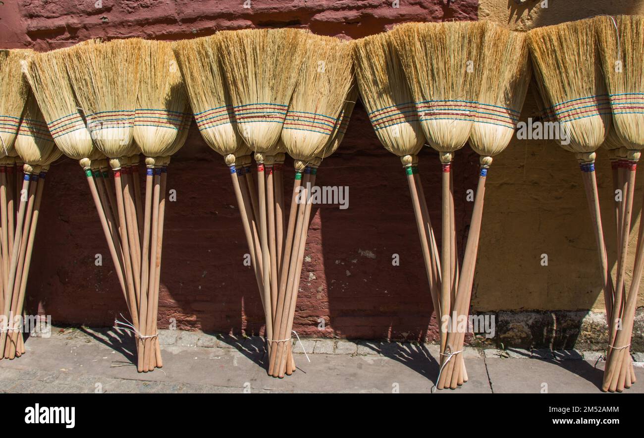 Set of yellow straw broom in a bazaar Stock Photo