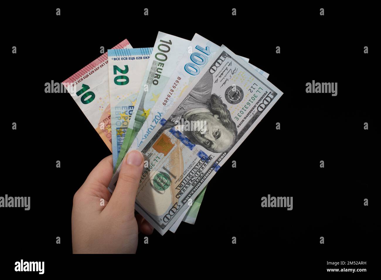 Hand holding American dollar banknotes isolated on black background ...