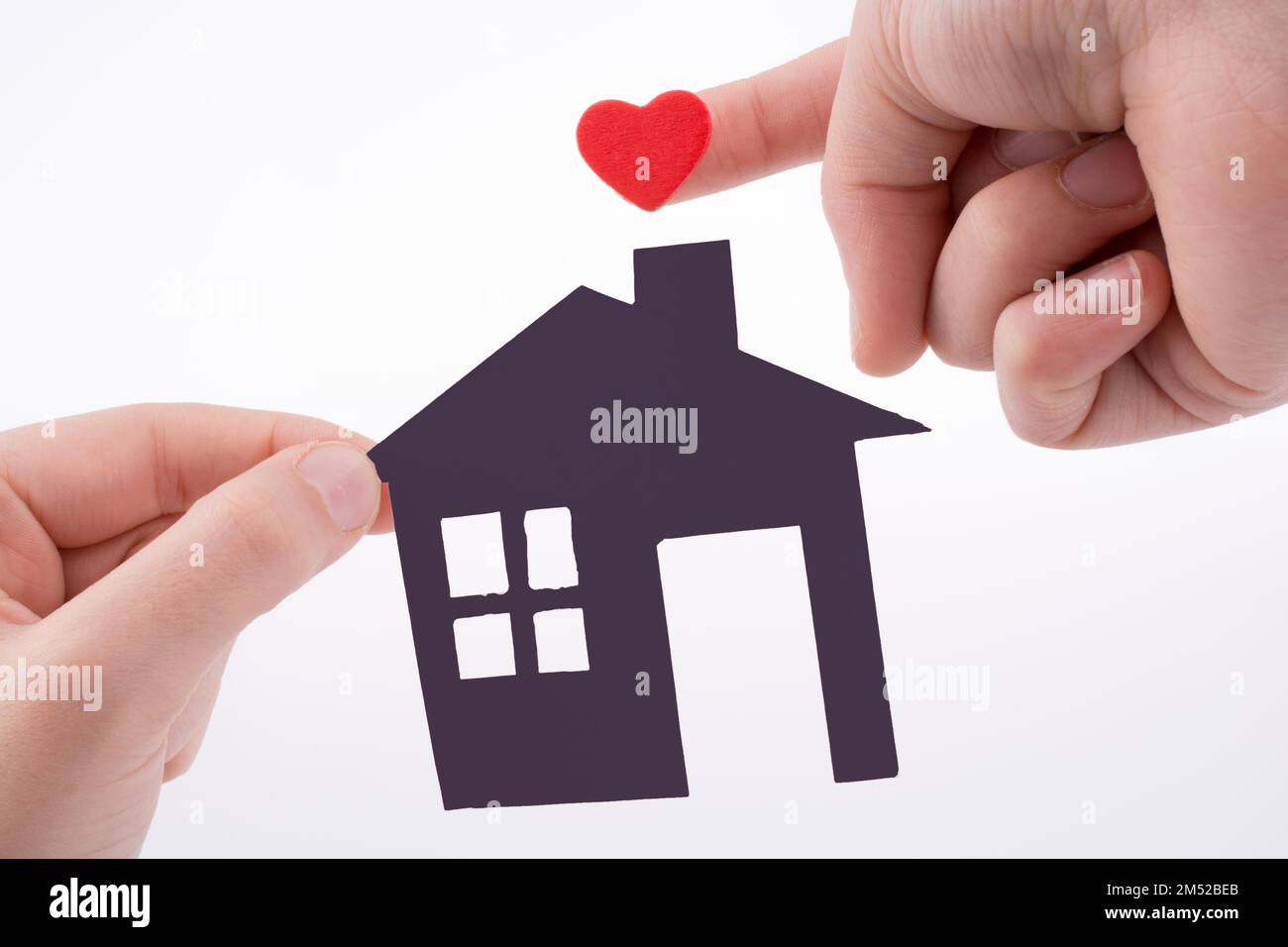 Paper house and heart shape in hand on a white background Stock Photo ...